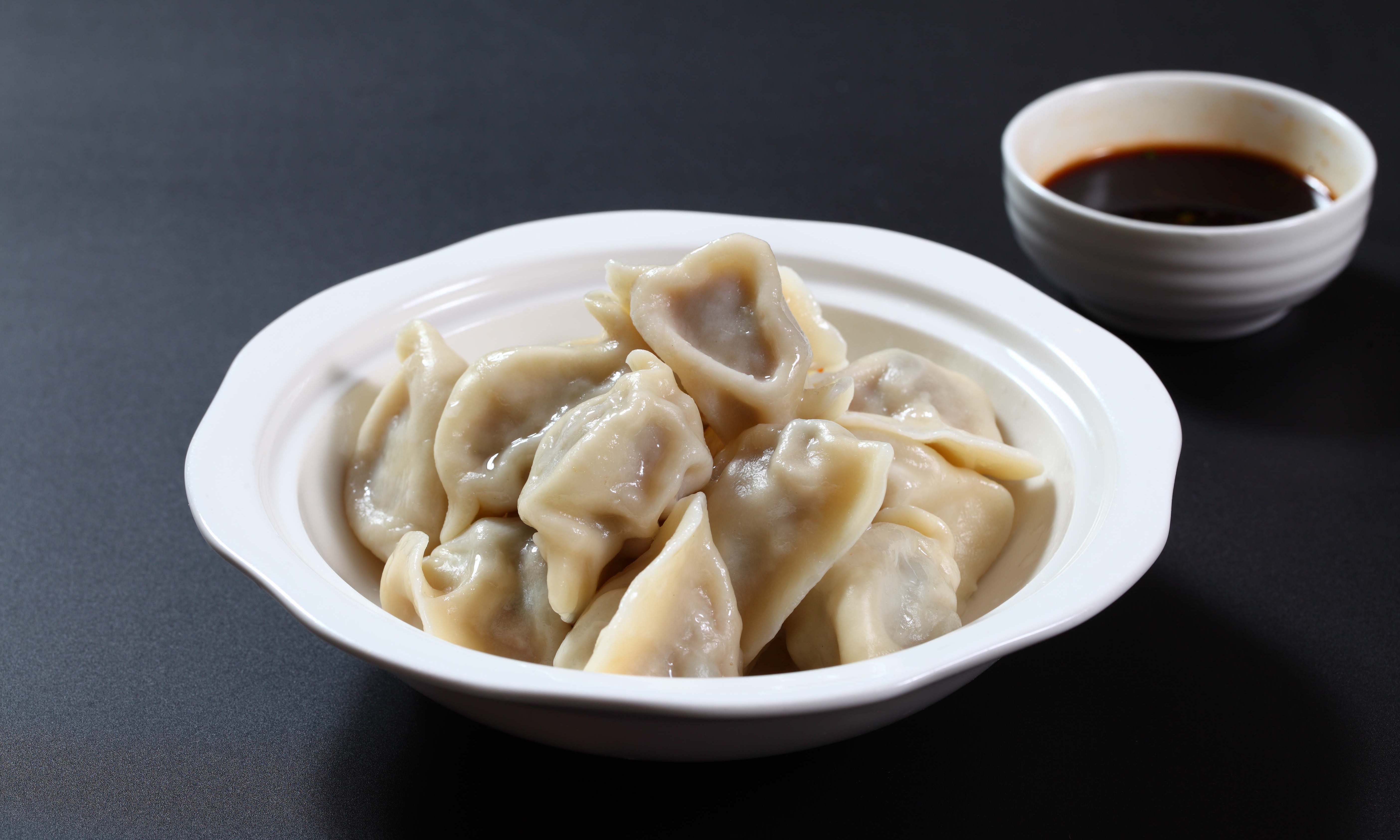 稍饧,揉匀后搓成条,下剂,擀成饺子皮,包入馅料,捏成鸳鸯形饺子生坯,在